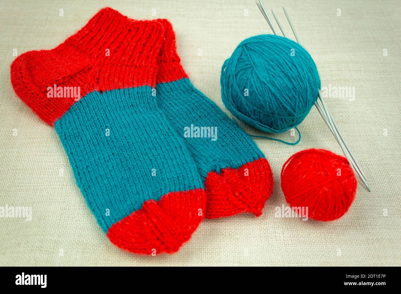 Chaussettes en fils de laine multicolores. Chaussettes tricotées à la maison. Chaussettes et fils tricotés en laine et aiguilles à tricoter Banque D'Images