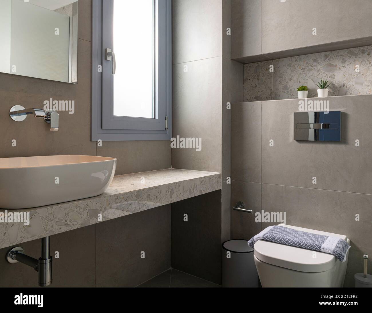 Intérieur de style contemporain de petite salle de bains moderne carrelée  de pierre de galet grise avec fenêtre, lavabo de bateau, WC mural caché  accroché Photo Stock - Alamy