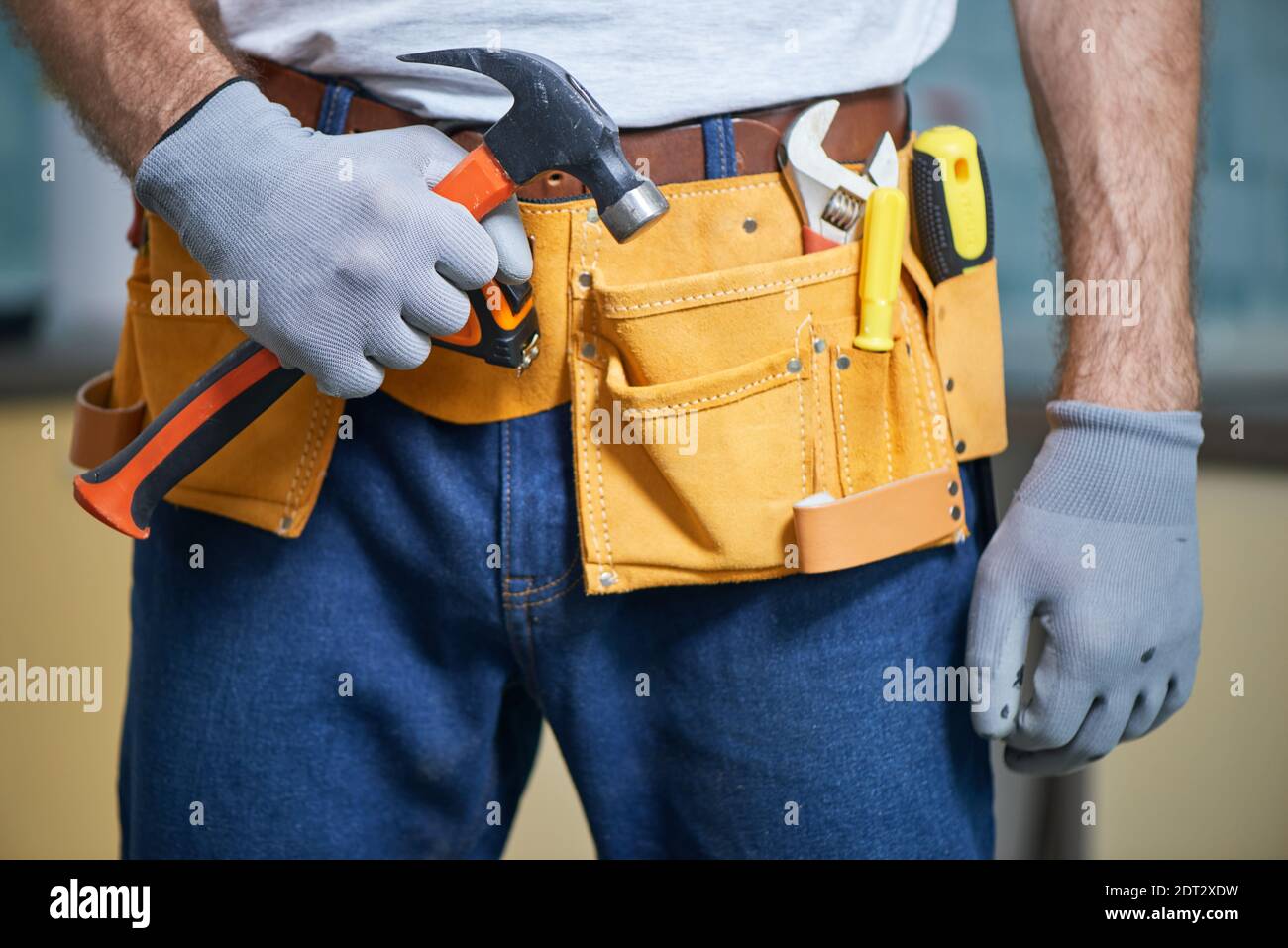 Prêt à tout réparer. Gros plan d'un réparateur portant une ceinture à  outils avec divers outils, tenant un marteau dans la main Photo Stock -  Alamy