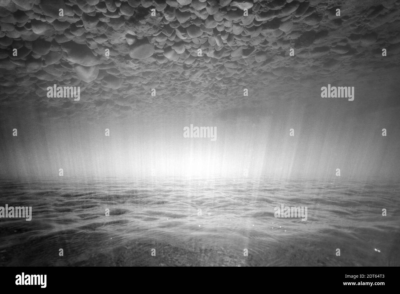 Vue sur les galets avec sunbeam sous l'eau Banque D'Images