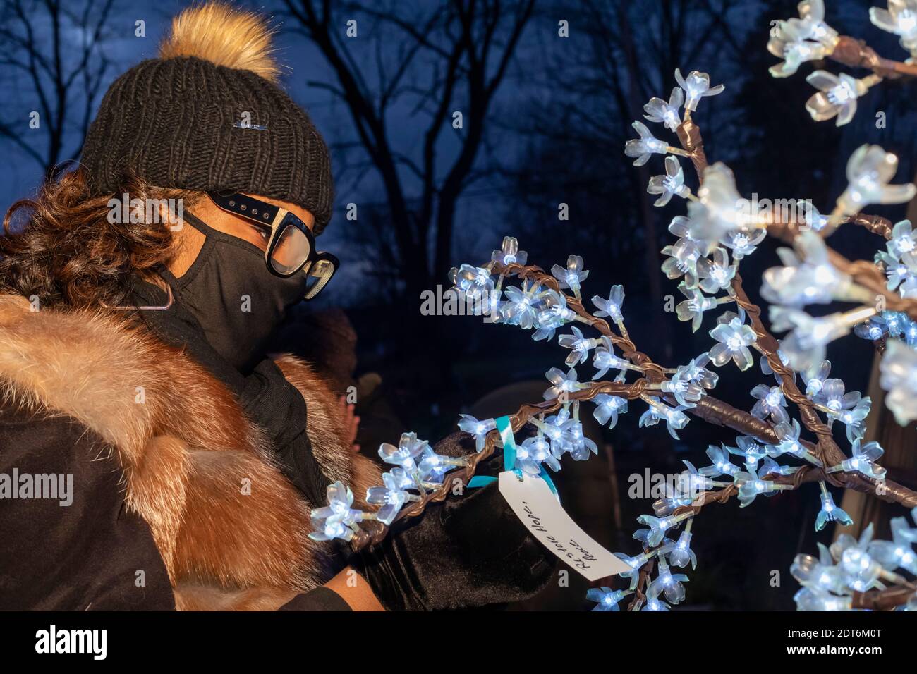 Detroit, Michigan, États-Unis. 20 décembre 2020. Lors d'un rassemblement de Solstice d'hiver, les voisins ont écrit et brûlé ce qu'ils voulaient oublier sur 2020, et ont affiché leurs espoirs pour 2021 sur un arbre de lumières. Crédit : Jim West/Alay Live News Banque D'Images