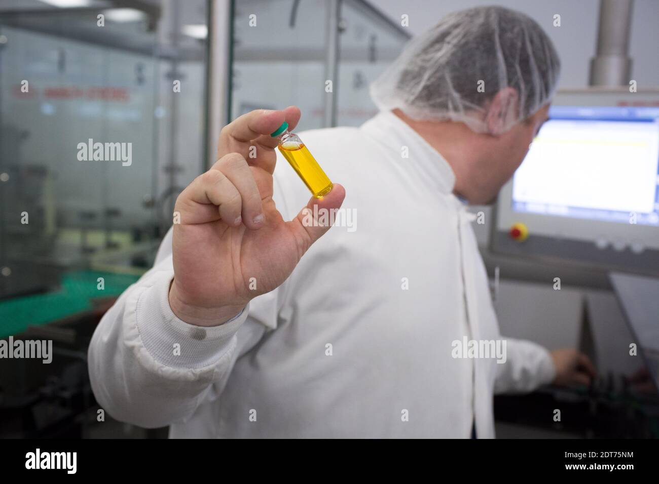 Un employé d'une usine de Novo Nordisk, une société de santé mondiale, présente un flacon d'insuline lors d'une visite du président français François Hollande à l'usine de Novo Nordisk à Chartres, en France, le 17 février 2014. Photo de Revelli-Beaumont/Pool/ABACAPRESS.COM Banque D'Images