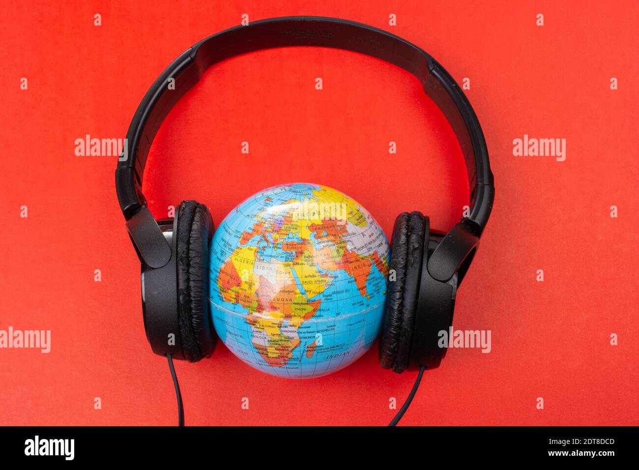 Micro-casque sur globe isolé sur le rouge Banque D'Images