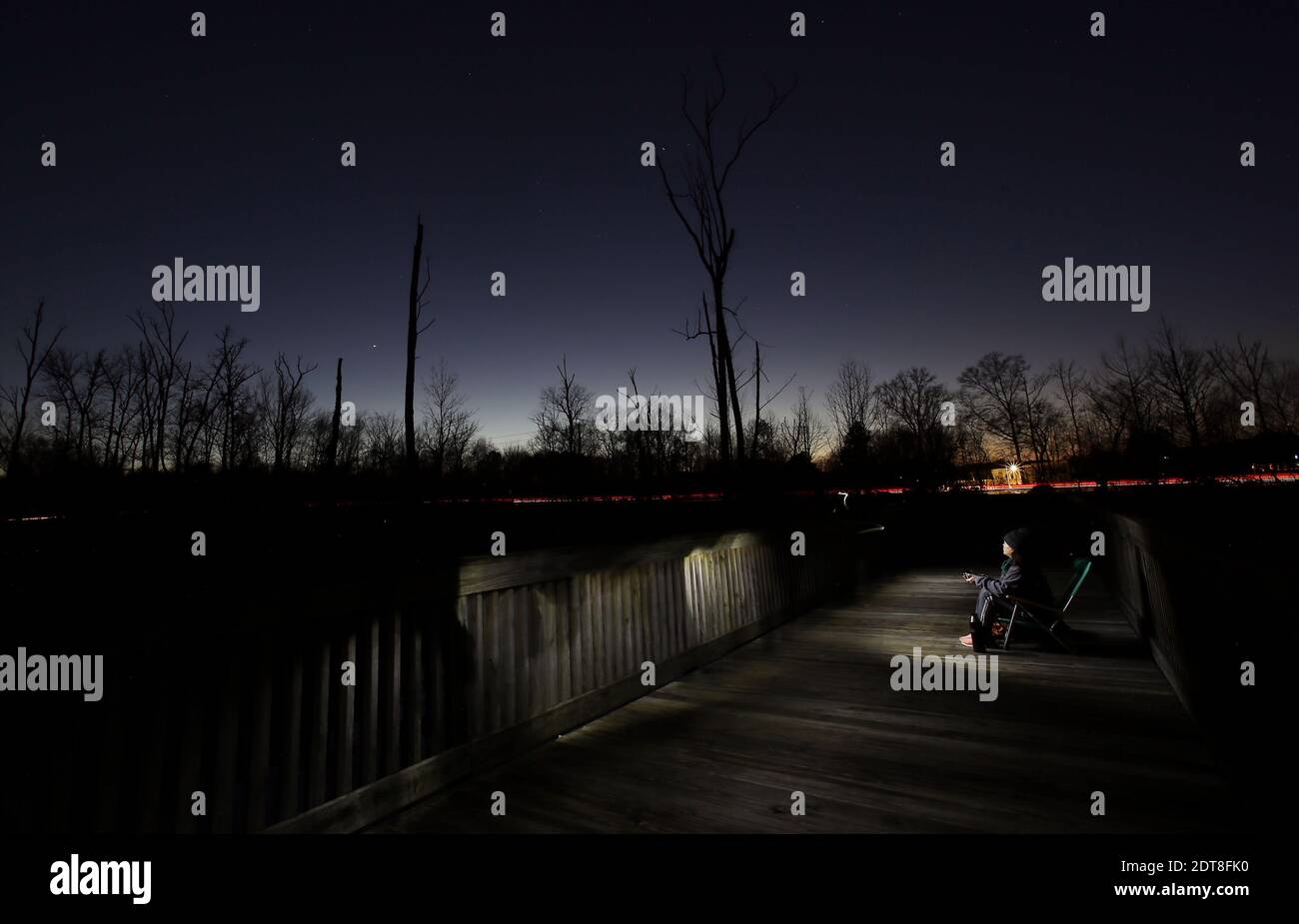 Cary, Caroline du Nord, États-Unis. 21 décembre 2020. CLAUDIA FONSECA de Cary, NC montres de la plate-forme de White Oak Greenway Wetlands à Cary, NC comme Jupiter et Saturne, (en bas à gauche du centre) Les deux plus grands mondes de notre système solaire s'alignent dans le ciel nocturne si étroitement qu'ils créent un point de lumière rayonnante appelé ''˜étoile de Bethléem' ou ''˜étoile de Noël.' La grande conjonction de Jupiter et de Saturne en 2020 sera la plus proche depuis 1623 et la plus proche observable depuis 1226. Crédit : Bob Karp/ZUMA Wire/Alay Live News Banque D'Images