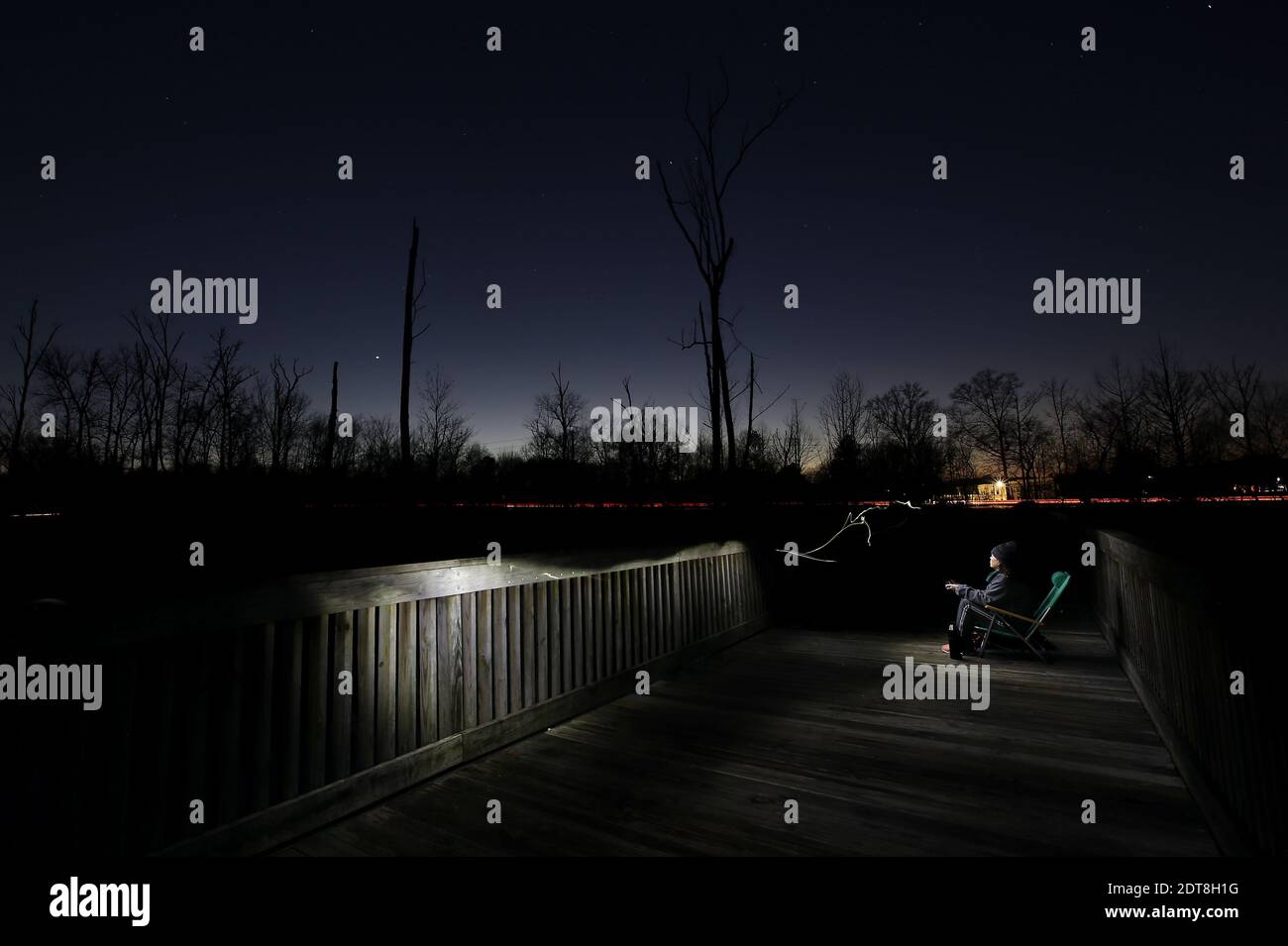 Cary, Caroline du Nord, États-Unis. 21 décembre 2020. CLAUDIA FONSECA de Cary, NC montres de la plate-forme de White Oak Greenway Wetlands à Cary, NC comme Jupiter et Saturne, (en bas à gauche du centre) Les deux plus grands mondes de notre système solaire s'alignent dans le ciel nocturne si étroitement qu'ils créent un point de lumière rayonnante appelé ''˜étoile de Bethléem' ou ''˜étoile de Noël.' La grande conjonction de Jupiter et de Saturne en 2020 sera la plus proche depuis 1623 et la plus proche observable depuis 1226. Crédit : Bob Karp/ZUMA Wire/Alay Live News Banque D'Images