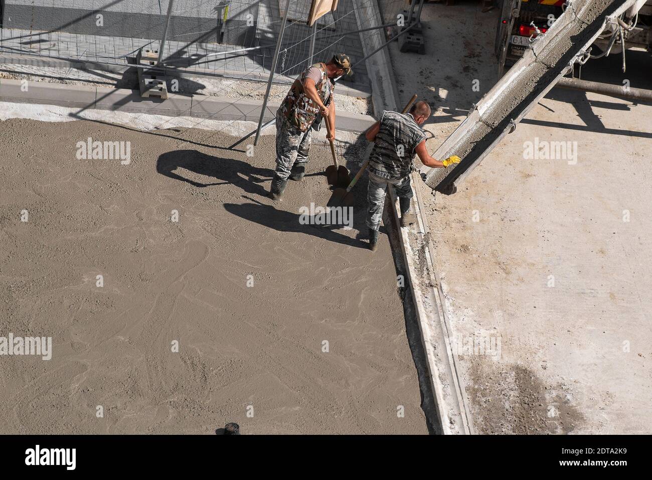 Deux hommes sont en béton sur le trottoir. Travaux de rénovation. Banque D'Images