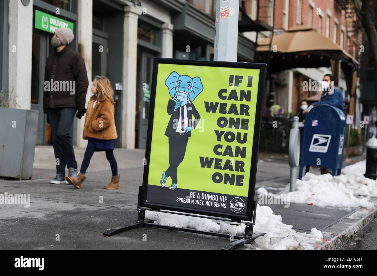 New York, États-Unis. 21 décembre 2020. Les gens marchent devant une affiche de suggestion pour la prévention de la COVID-19 à New York, aux États-Unis, le 21 décembre 2020. Le nombre total de cas de COVID-19 aux États-Unis a atteint lundi 18 millions, selon le Centre for Systems Science and Engineering (CSSE) de l'Université Johns Hopkins. Le nombre de cas COVID-19 aux États-Unis est passé à 18,006,061, avec un total de 319,190 décès, à 6 h 22, heure locale (2322 GMT), selon le calcul CSSE. Crédit : Wang Ying/Xinhua/Alay Live News Banque D'Images