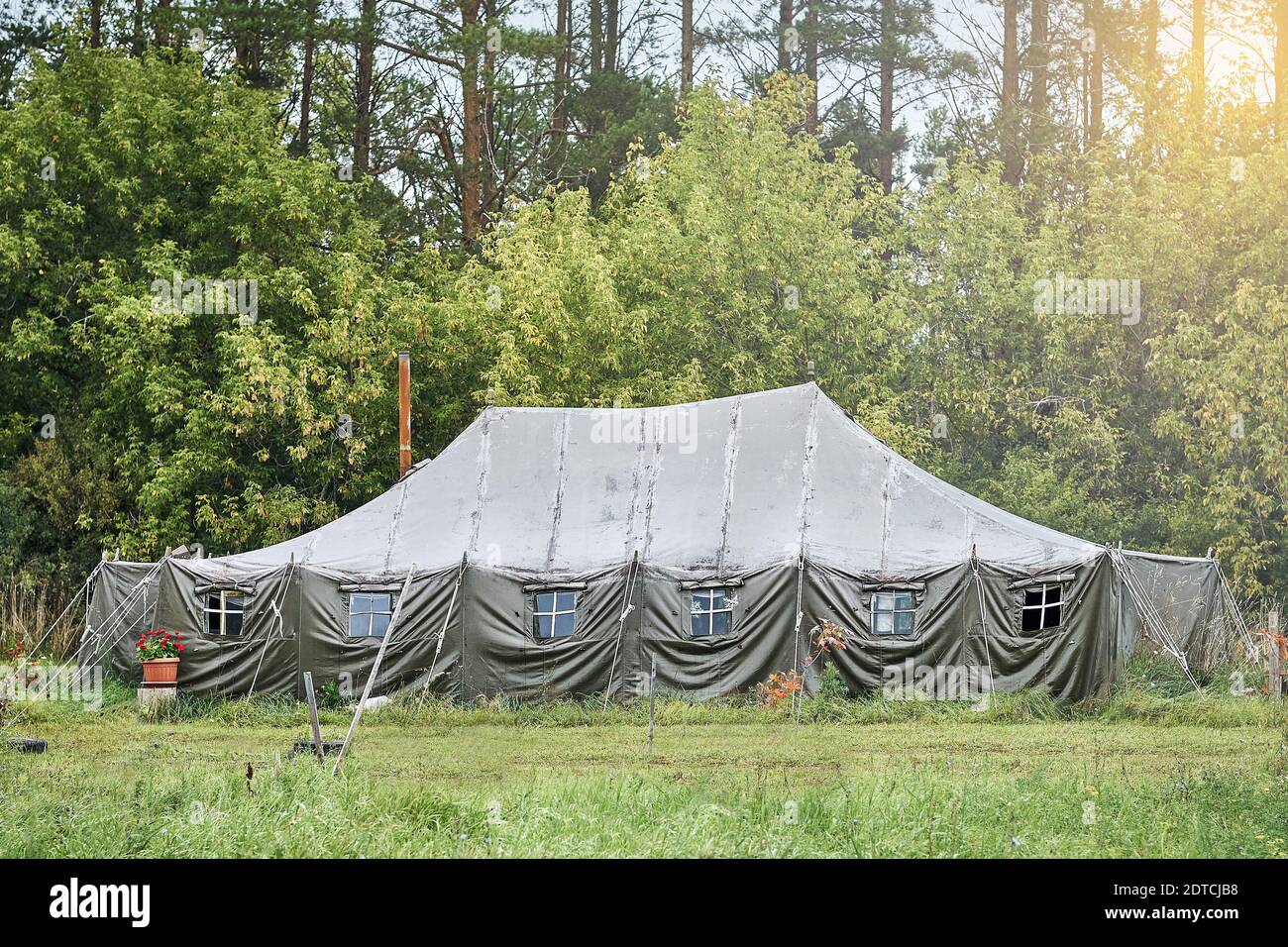 Grande tente militaire avec fenêtres et cuisinière la pelouse dans la forêt Banque D'Images
