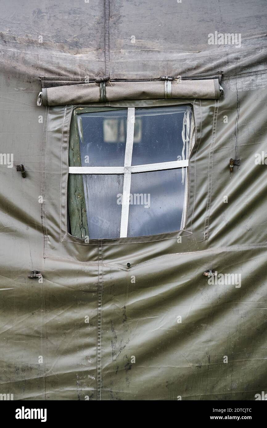 Grande tente militaire avec fenêtres et poêle sur la pelouse de la forêt. Vue rapprochée de la fenêtre de tente Banque D'Images
