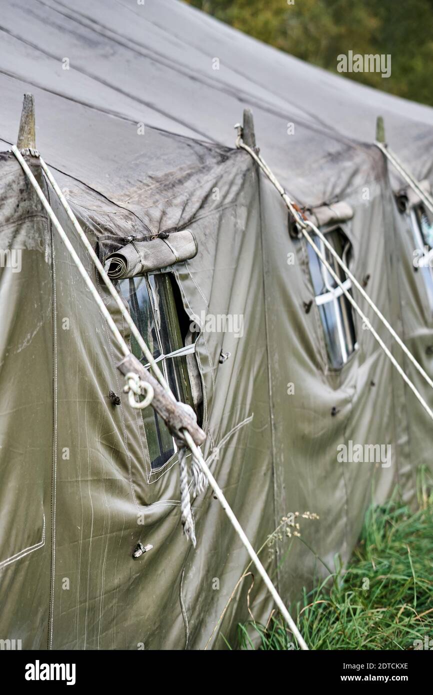 Grande tente militaire avec fenêtres et poêle sur la pelouse de la forêt. Vue rapprochée de la fenêtre de tente Banque D'Images