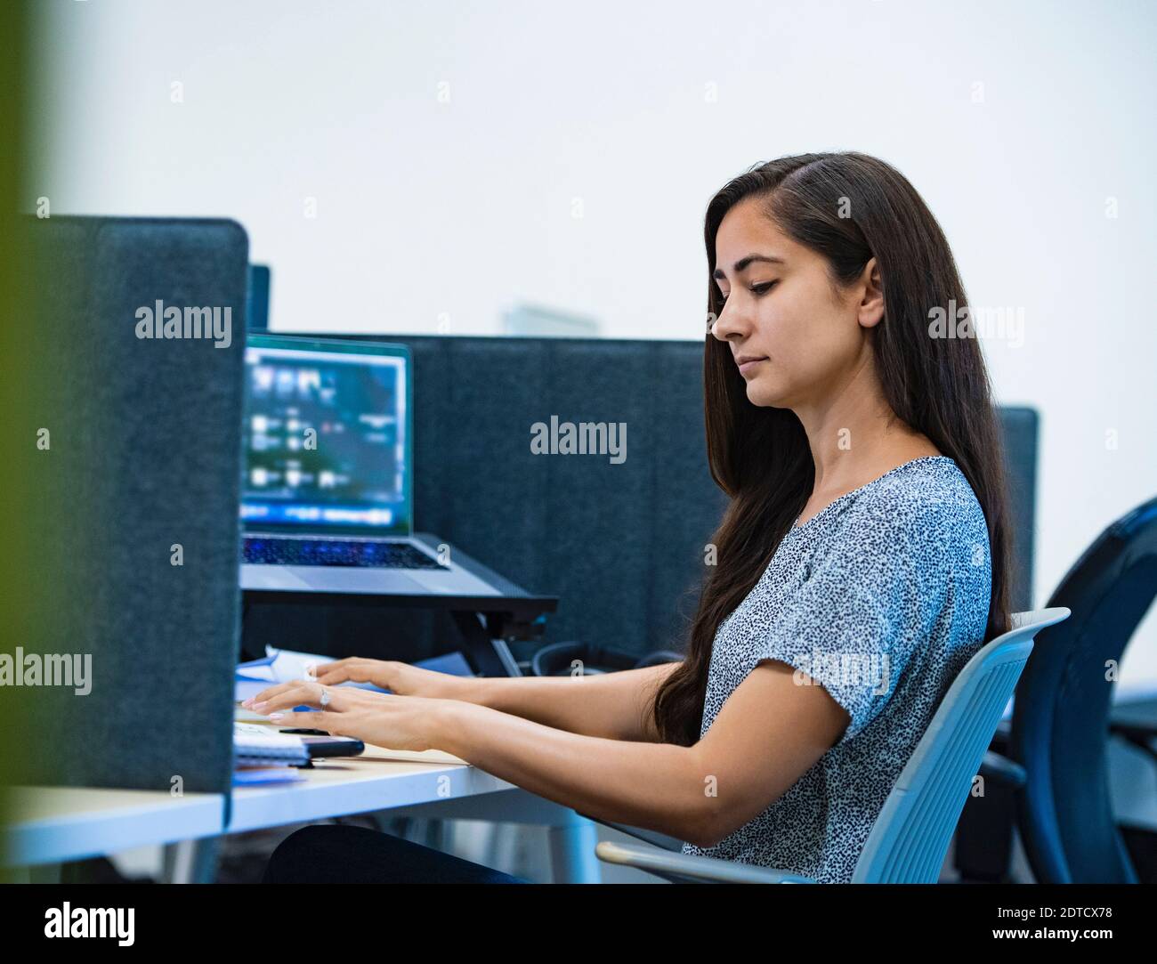 Femme utilisant un ordinateur au bureau Banque D'Images