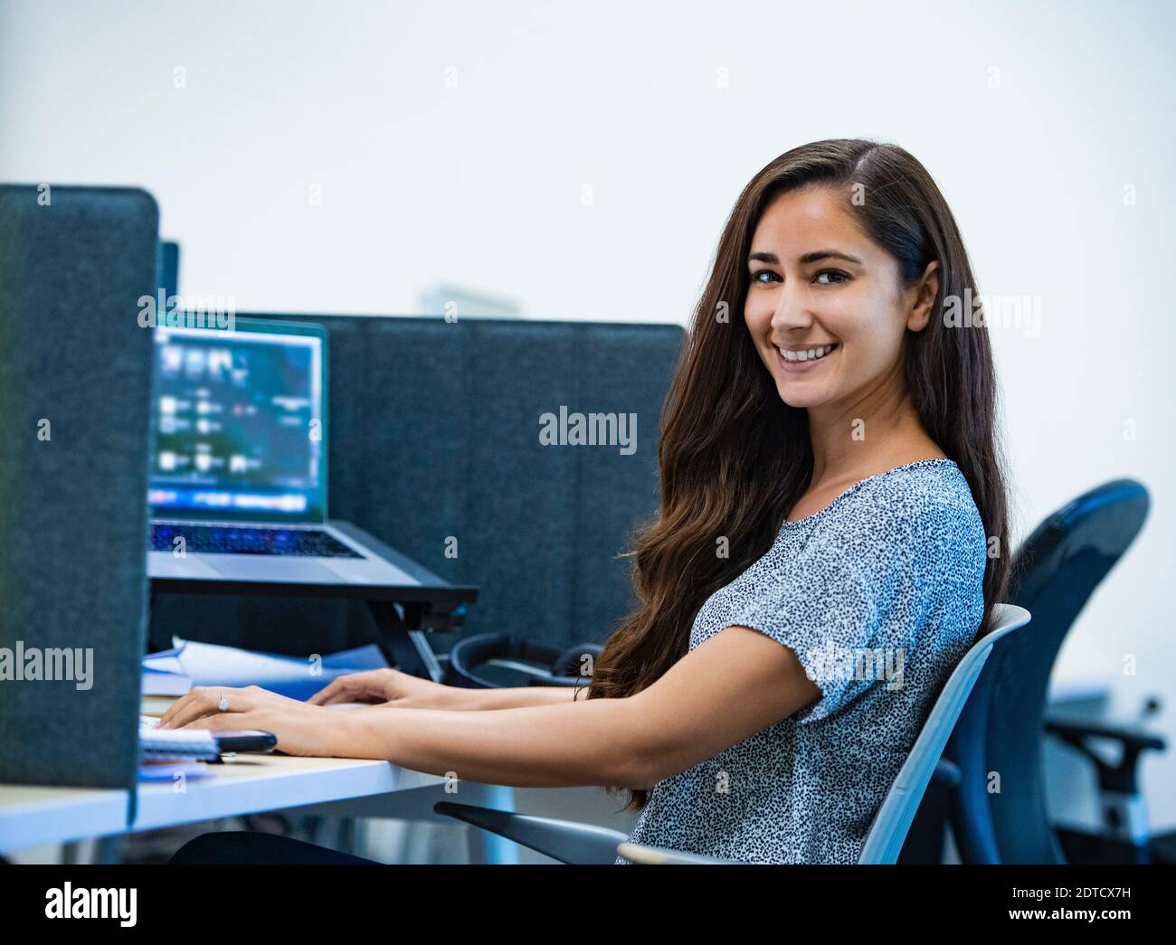 Portrait of smiling woman sitting at desk in office Banque D'Images