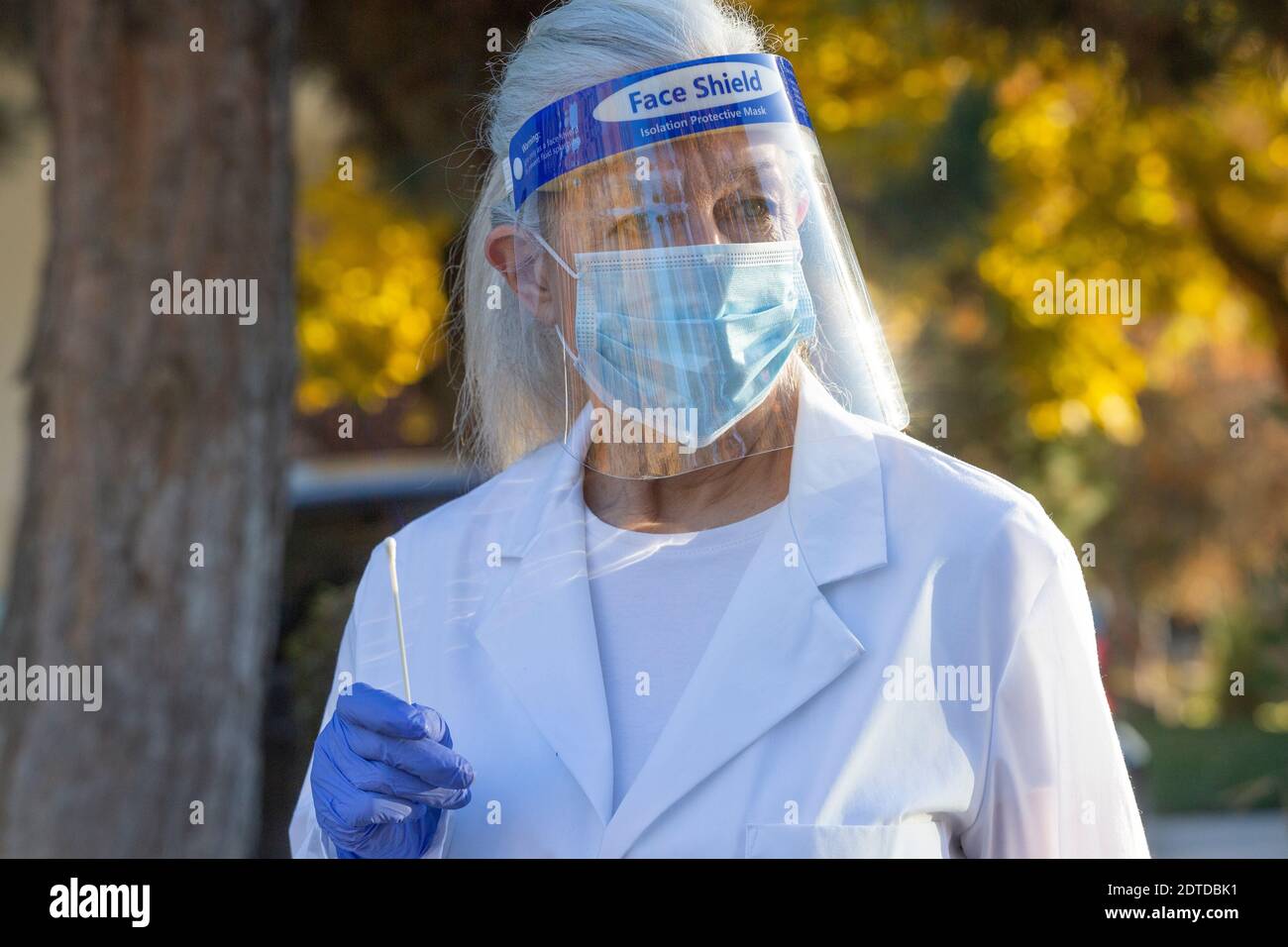 Personnel médical féminin portant des vêtements de protection et portant un test d'écouvillonnage du coronavirus à l'extérieur Banque D'Images