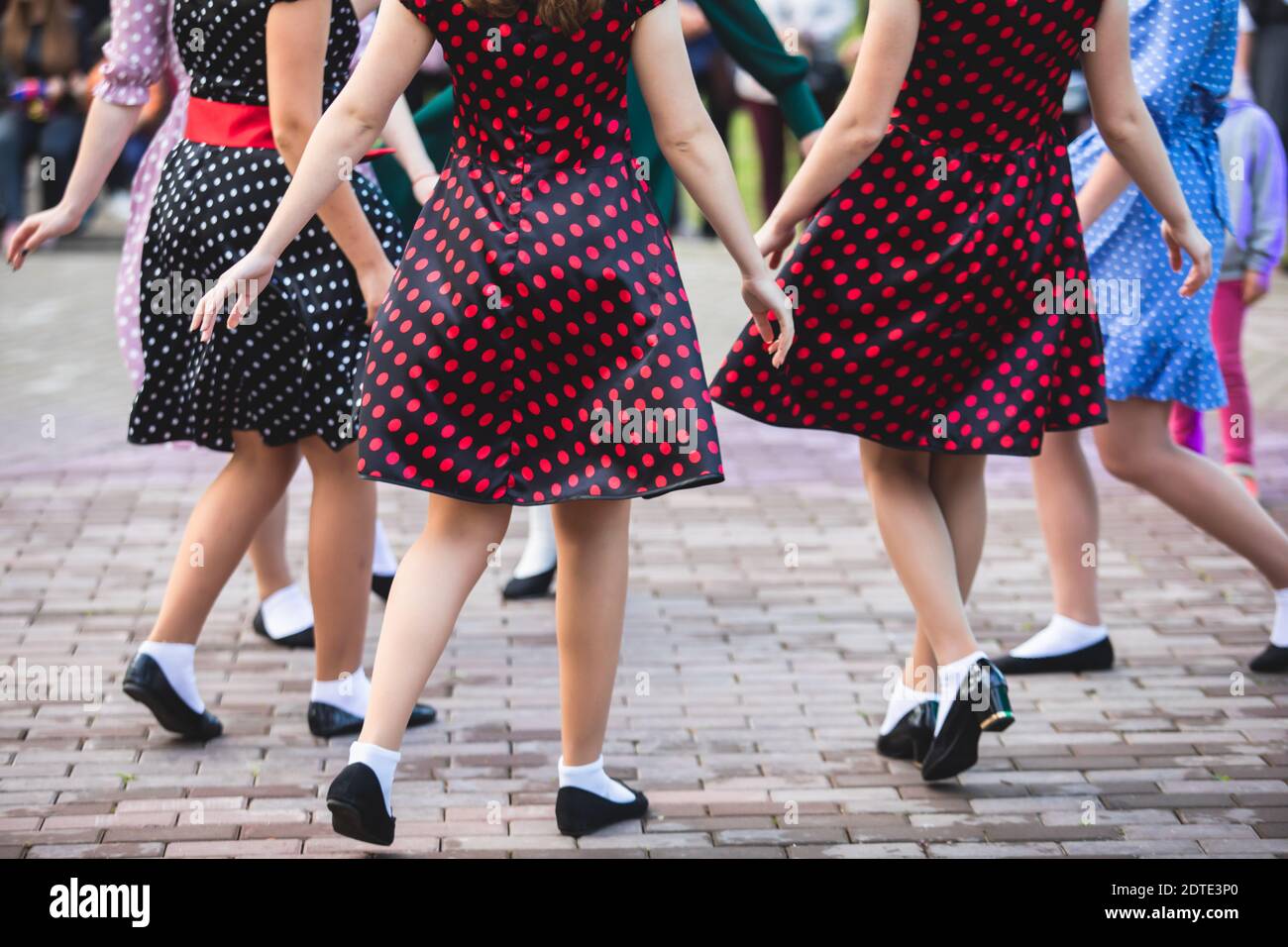 Jeunes femmes portant des robes à pois vintage dansant dans le parc de la  ville, vue rapprochée des mêmes chaussures de danse noires et des  chaussettes blanches, swing rétro de jazz féminin