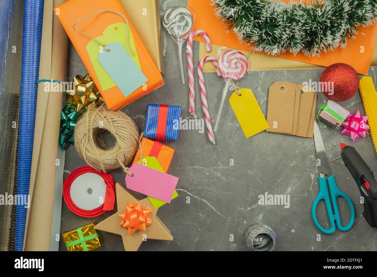 Emballer les cadeaux à la main dans du papier cadeau sur la table comme arrière-plan ou vierge. Emballage cadeau pour noël ou nouvel an, vue du dessus Banque D'Images