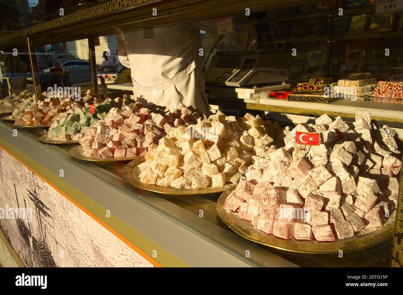 Desserts turcs doux lokum près de la fenêtre dans la rue. Petits drapeaux turcs au centre d'une assiette de bonbons. Istanbul, Turquie. Banque D'Images