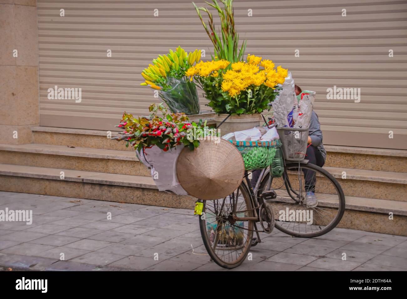 Un vendeur de rue vendant des fleurs sur un vélo à Hanoi, Vietnam Banque D'Images
