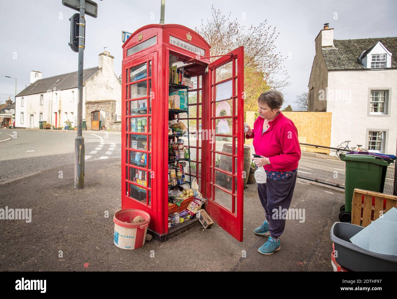 EXAMEN par l'AP DU dossier DE L'AN 2020 photo datée du 14/04/20 de Susan Crawford vérifiant la larrière alimentaire communautaire à Muthill, près de Crieff dans le Perthshire, Qui a été mis en place par les résidents locaux en utilisant l'ancienne boîte téléphonique du village comme une collecte de nourriture et un point de don alors que le Royaume-Uni continue à se verrouiller pour aider à freiner la propagation du coronavirus. Banque D'Images