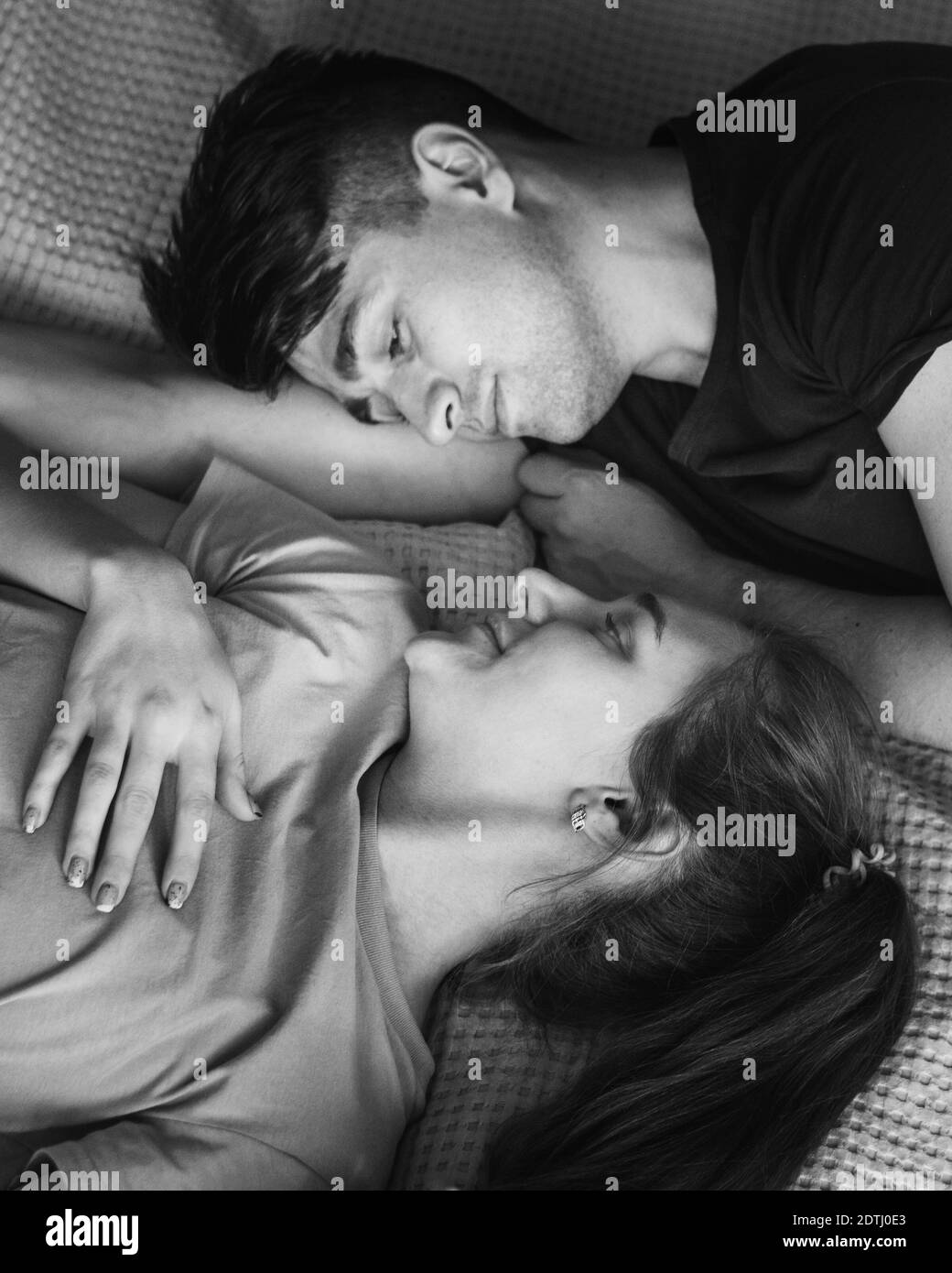 Couple heureux allongé dans le lit ensemble à la maison Banque D'Images