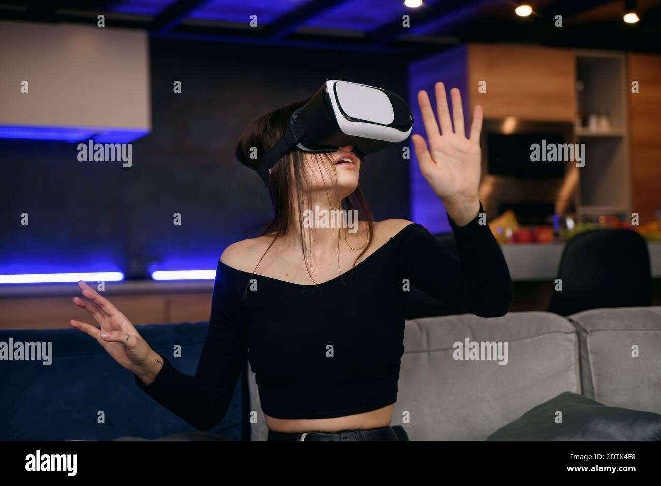 Concept de réalité virtuelle. Excitée belle fille adulte utilise le casque  VR jouant le jeu vidéo dans le salon confortable et élégant Photo Stock -  Alamy