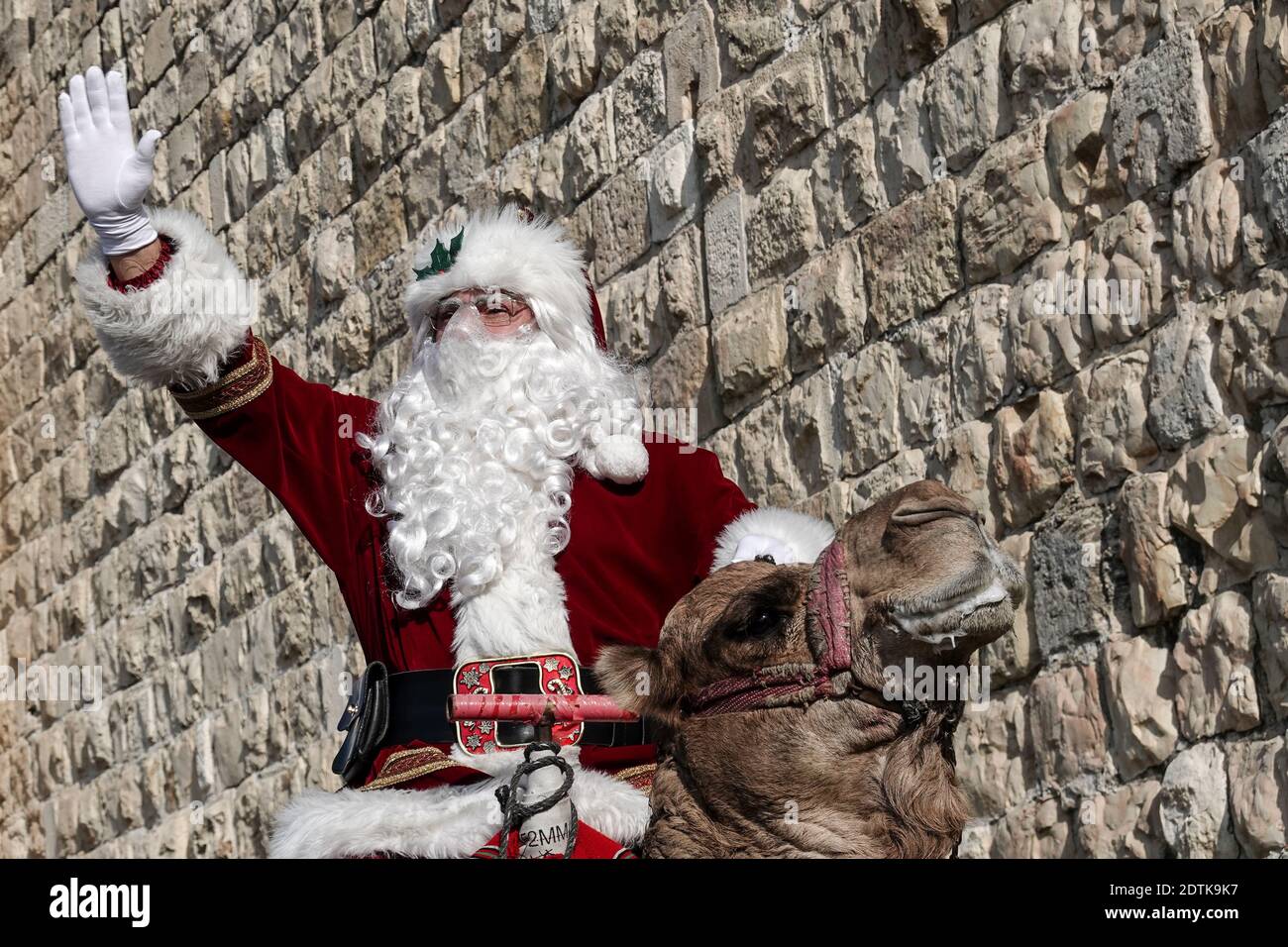 Jérusalem, Israël. 22 décembre 2020. Le Père Noël, ou « Baba Noel » comme  il est appelé en arabe, se déplace à dos de chameau pour remplacer le renne  près de la