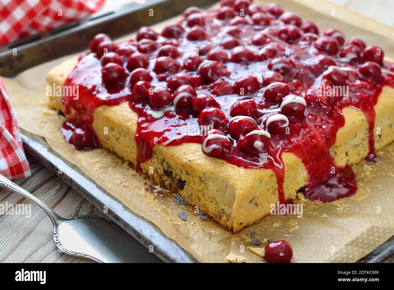 Gâteau sucré à la stracciatella recouvert de gelée de fruits rouges, de cerises et de sauce à la vanille Banque D'Images