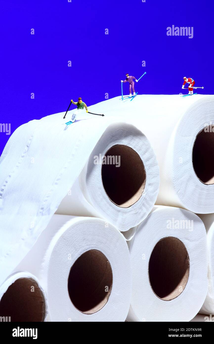 Image conceptuelle de la figure miniature des gens skant sur un rouleau de toilettes tissu Banque D'Images