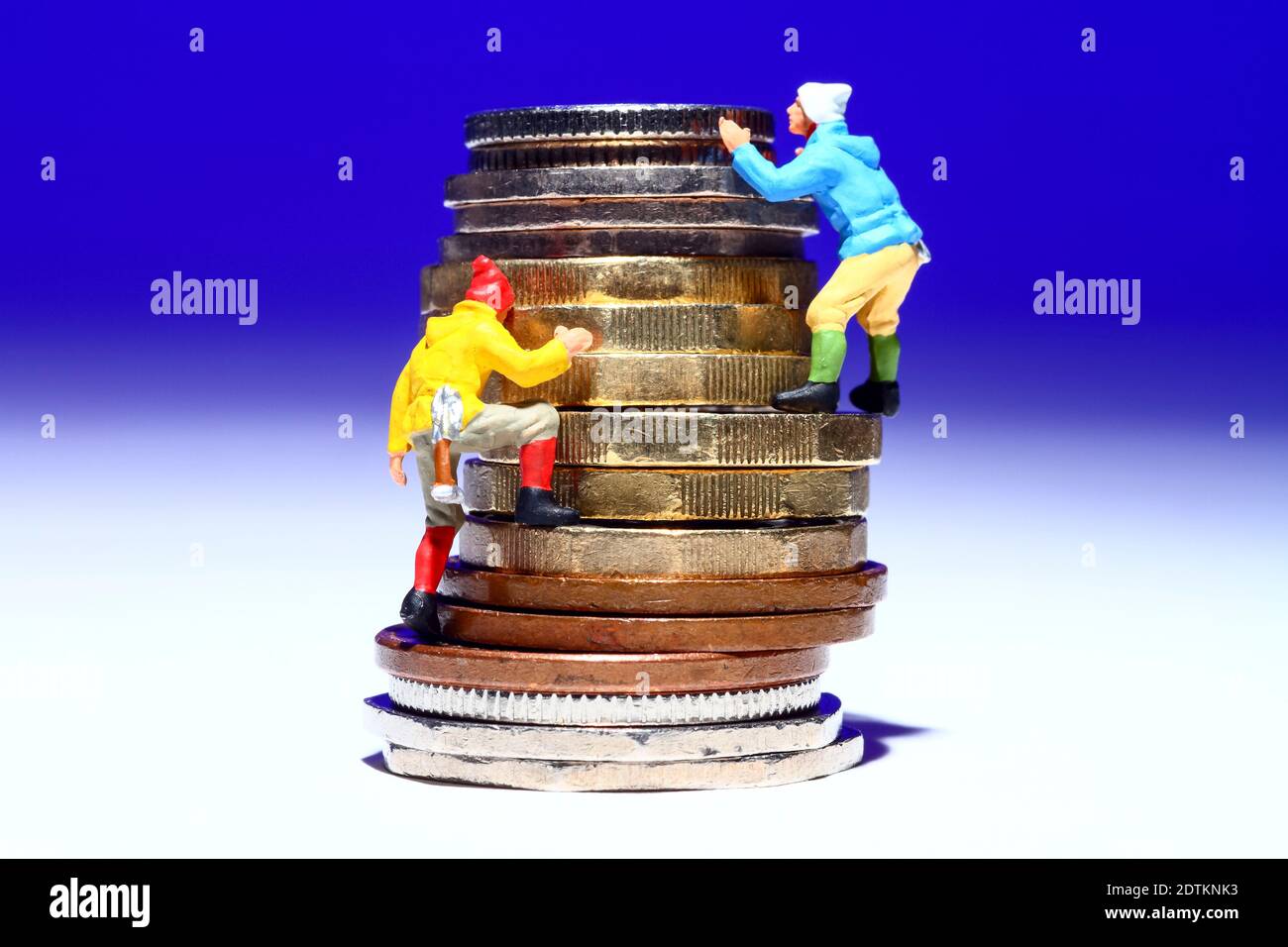 image conceptuelle de la figure miniature de personnes grimpant une pile de des pièces pour atteindre leur but monétatoire Banque D'Images