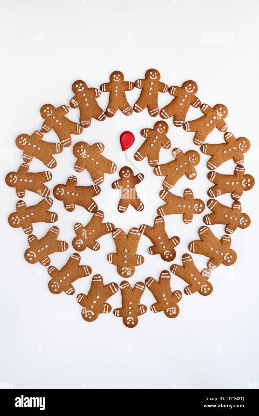 Biscuits Gingerbread Men avec un ballon rouge sur fond blanc. Répétition Banque D'Images