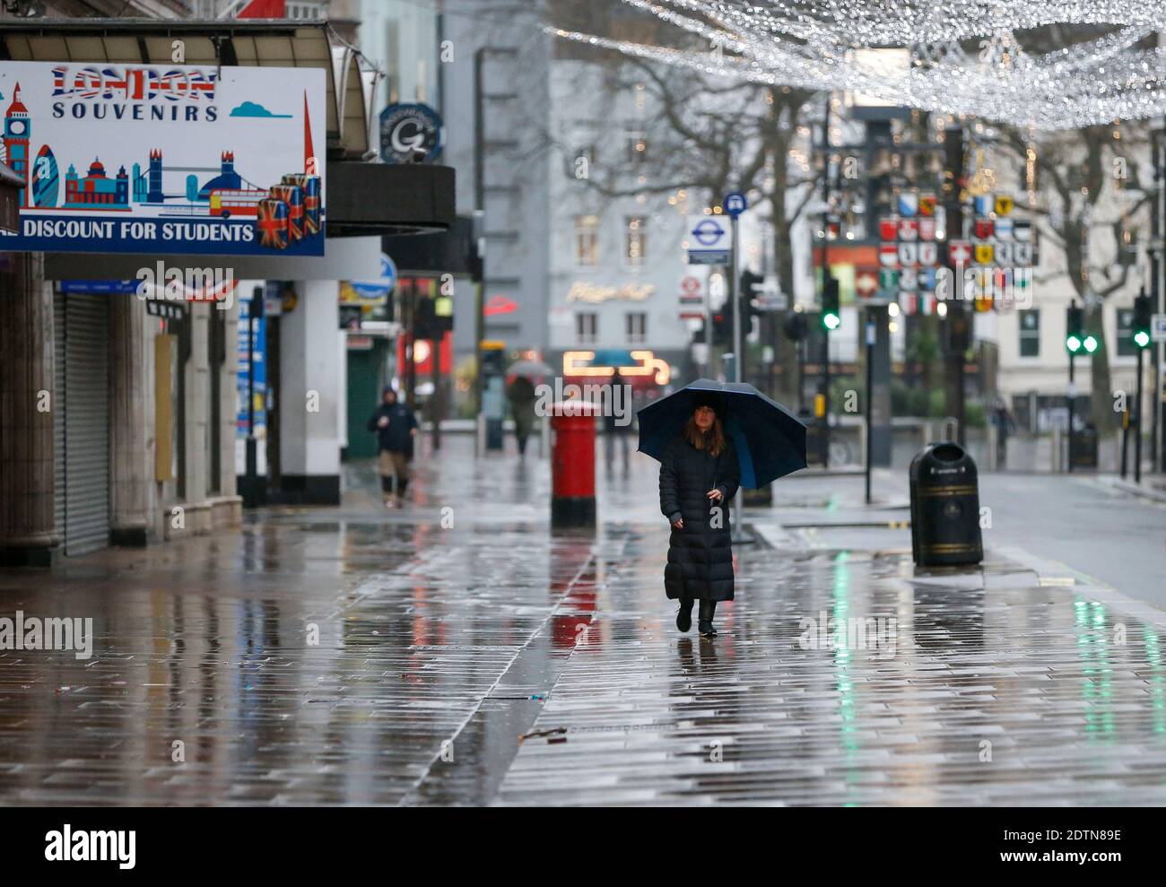 Londres, Grande-Bretagne. 21 décembre 2020. Une femme marche dans une rue vide près de Leicester Square à Londres, en Grande-Bretagne, le 21 décembre 2020. Credit: Han Yan/Xinhua/Alay Live News Banque D'Images