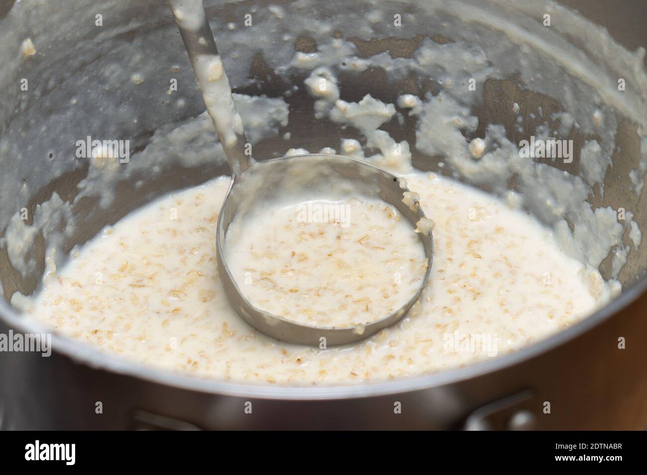 Grande casserole de porridge de flocons d'avoine juste préparé avec un louche en cantine Banque D'Images