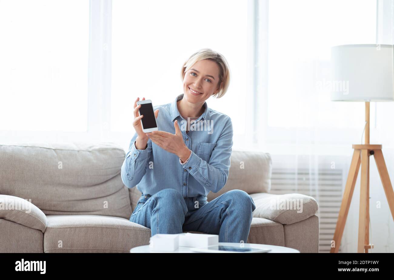 Une femme célèbre blogueuse annonçant un nouveau modèle de smartphone, filmant la revue vidéo de gadget moderne à la maison Banque D'Images