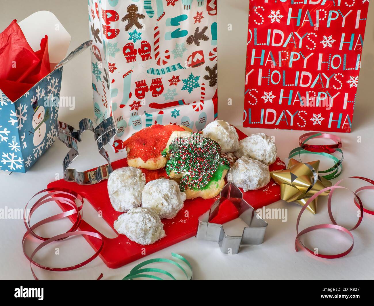 Assortiment de biscuits de Noël sur un tableau rouge avec vacances emballages et ruban Banque D'Images