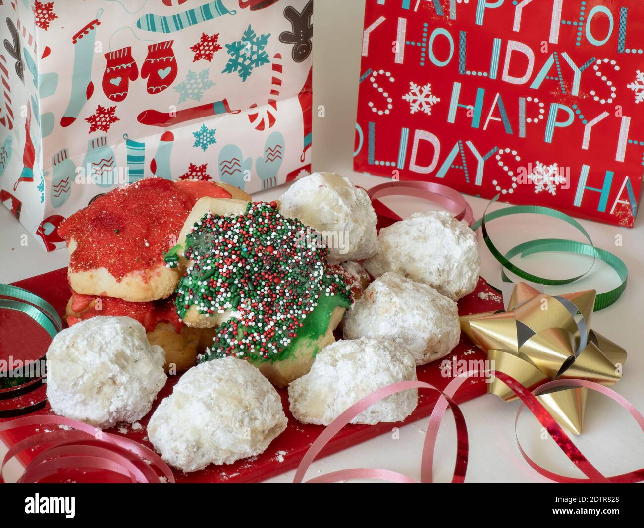 Assortiment de biscuits de Noël sur un tableau rouge avec vacances emballages et ruban Banque D'Images