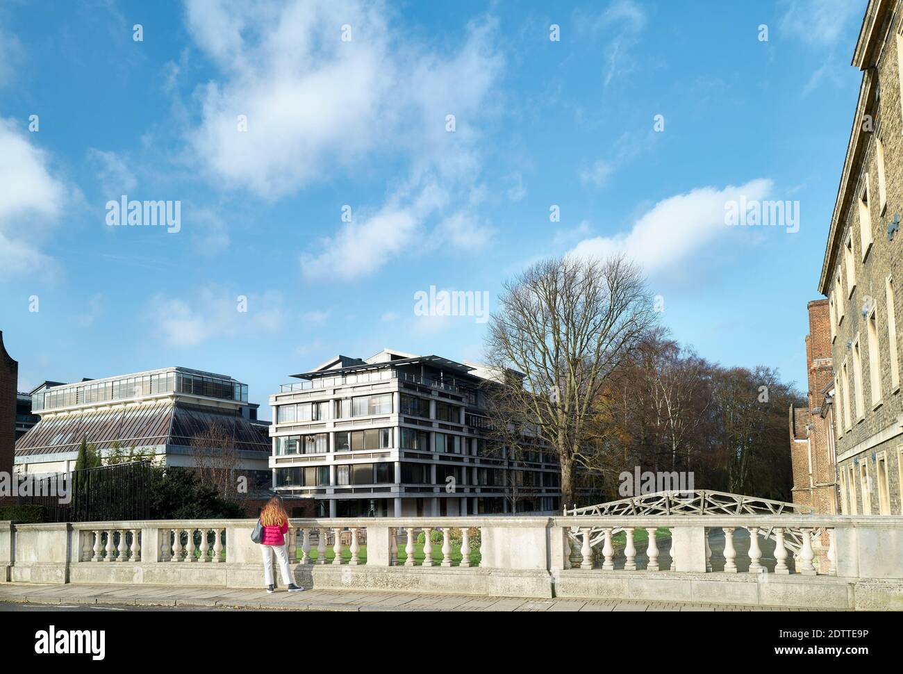 Une étudiante féminine se trouve à côté du parapet du pont routier au-dessus de la rivière Cam, à l'extérieur du Queenss' College, à l'université de Cambridge, en Angleterre. Banque D'Images