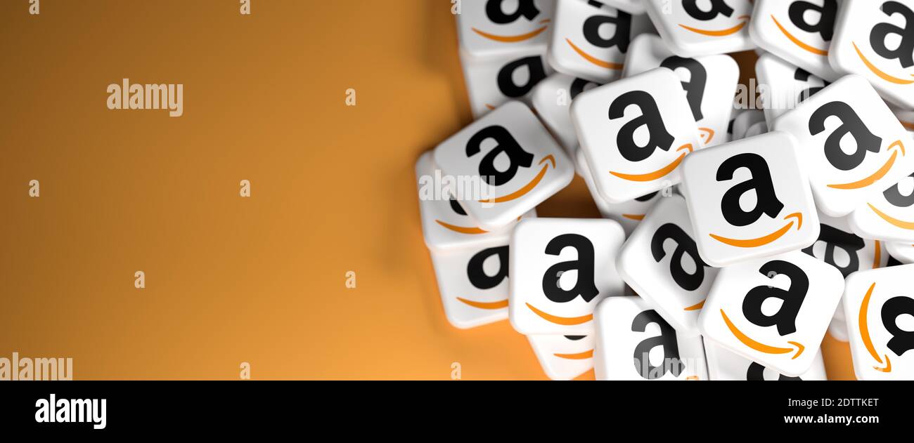 Logos de la société de commerce électronique et de cloud computing Amazon sur un tas sur une table. Espace de copie et mise au point sélective. Format de bannière Web. Banque D'Images