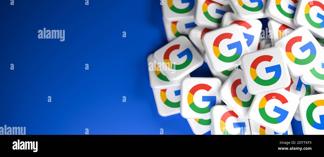 Logos de la société Google / Alphabet sur un tas sur une table. Espace de copie et mise au point sélective. Format de bannière Web. Banque D'Images