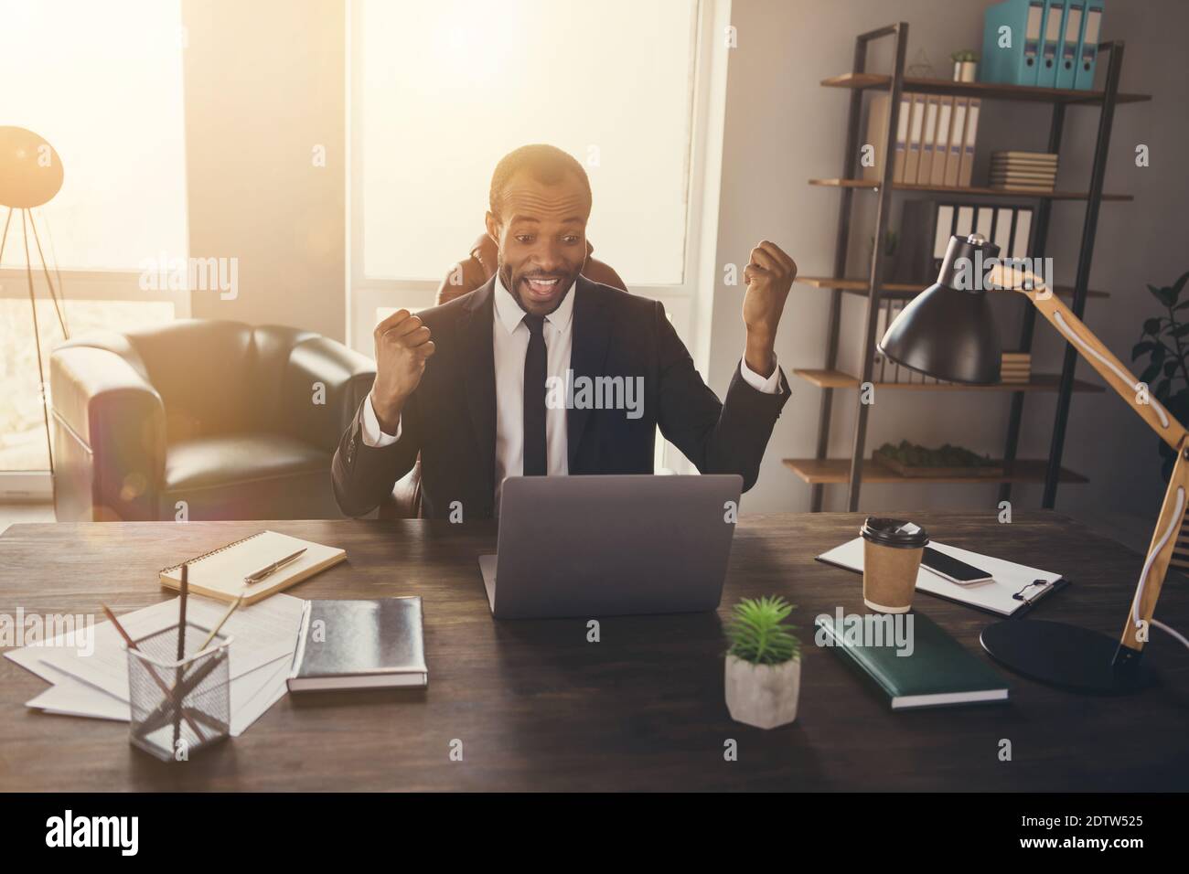 Portrait d'un homme afro-américain ravie assis bureau ordinateur portable de travail célébrez le partenariat atteindre le contrat soulever les poings crier oui porter tux combinaison tuxedo Banque D'Images