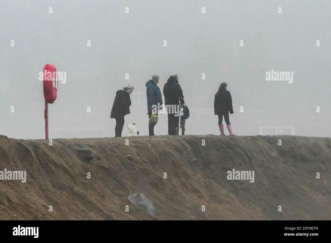 West Bay, Dorset, Royaume-Uni. 22 décembre 2020. Météo Royaume-Uni. Les gens qui s'exercent sur la plage de West Bay à Dorset lors d'un après-midi fade sourd et couvert. Crédit photo : Graham Hunt/Alamy Live News Banque D'Images