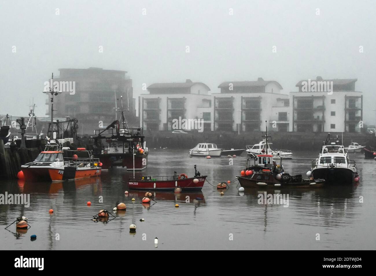 West Bay, Dorset, Royaume-Uni. 22 décembre 2020. Météo Royaume-Uni. Vue sur le port de West Bay à Dorset, un après-midi sombre et couvert de brume. Crédit photo : Graham Hunt/Alamy Live News Banque D'Images