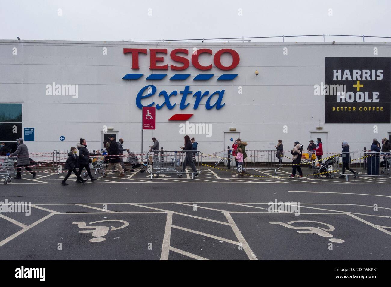 Watford, Royaume-Uni. 22 décembre 2020. Les clients font la queue à l'extérieur de la superboutique supplémentaire Tesco à Watford, dans le Hertfordshire. Le comté, ainsi qu'une grande partie du Royaume-Uni, est dans le Tier 4, restent à la maison, le niveau d'alerte étant donné que la pandémie du coronavirus se poursuit et la détection d'une nouvelle souche mutante exerce des pressions sur le gouvernement britannique pour qu'il mette en place un verrouillage national. Les craintes d'un manque de nourriture fraîche ont commencé à acheter panique dans certaines régions. Credit: Stephen Chung / Alamy Live News Banque D'Images