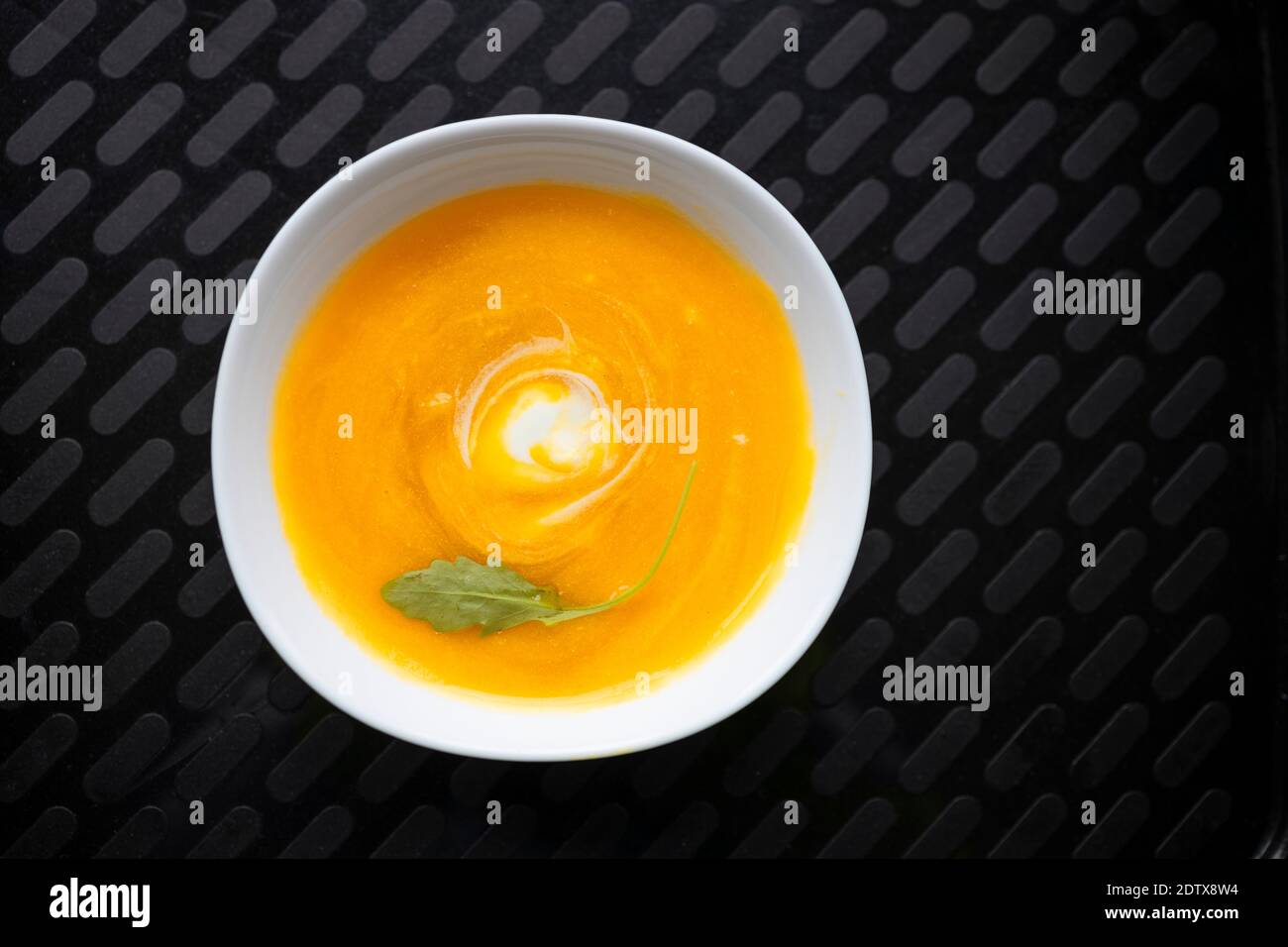 Assiette saine de soupe de courge servie sur un plateau noir Banque D'Images