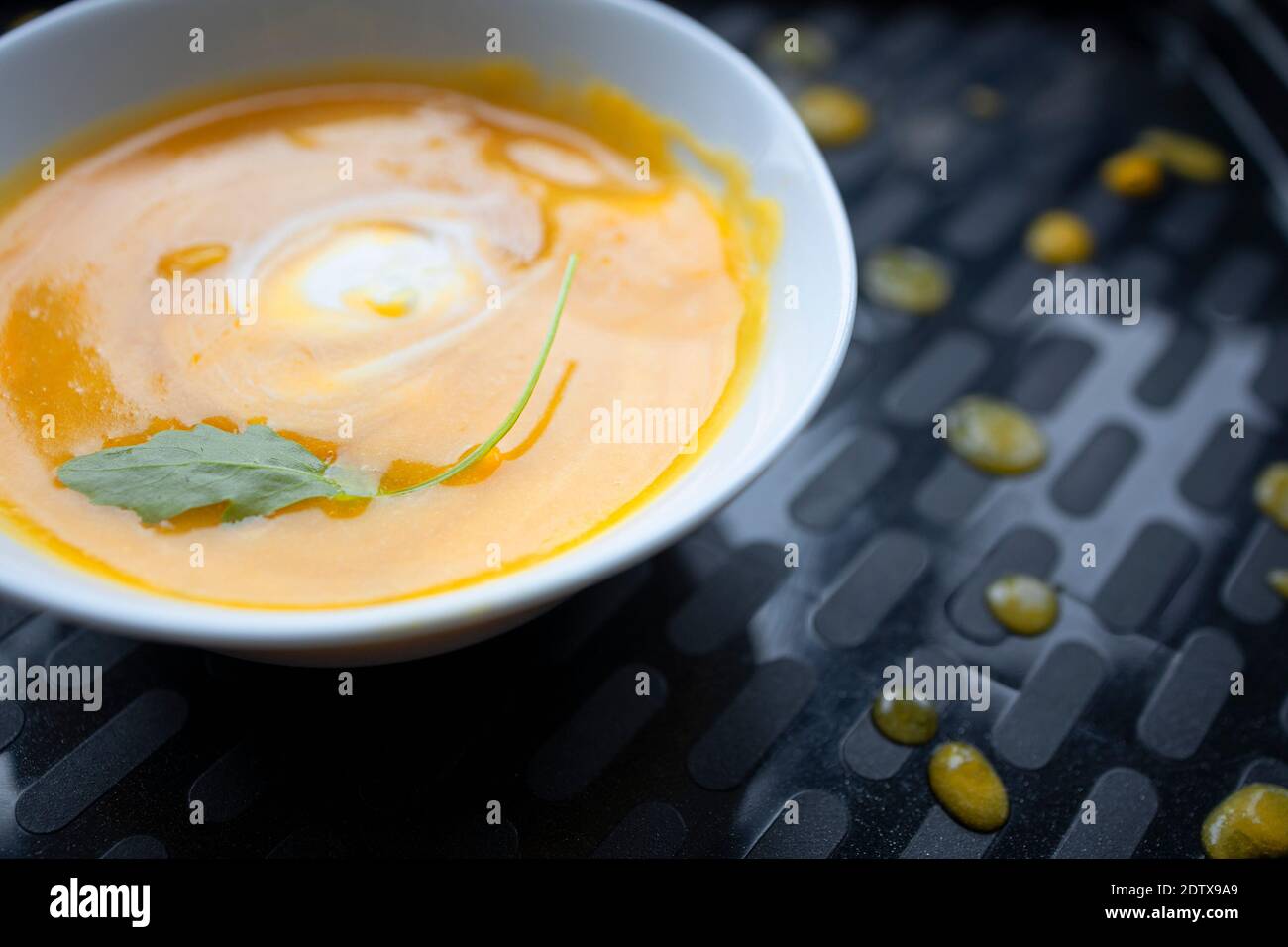 Assiette saine de soupe de courge servie sur un plateau noir Banque D'Images