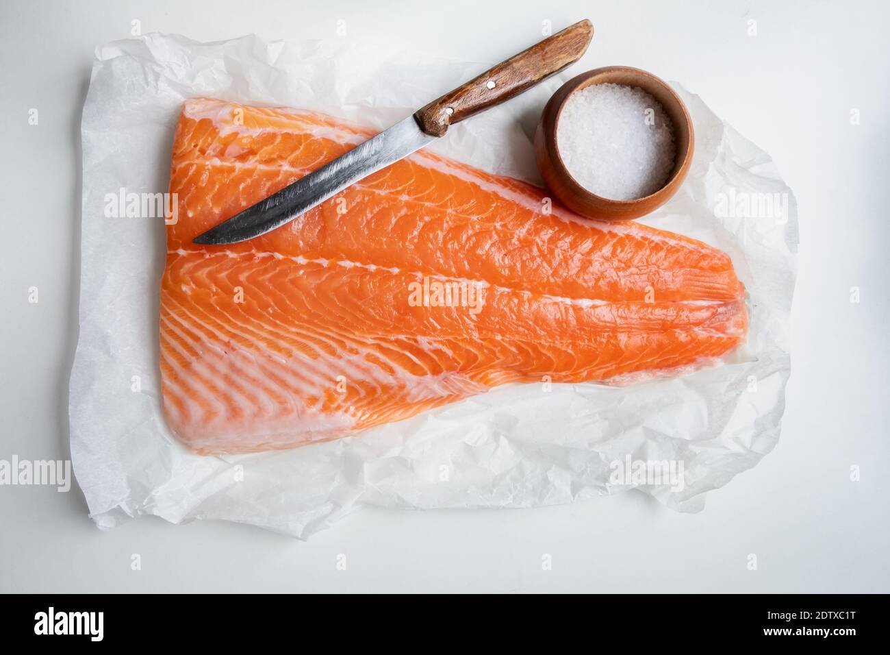 Filet de saumon sur table en bois avec couteau et sel. Photographie alimentaire Banque D'Images