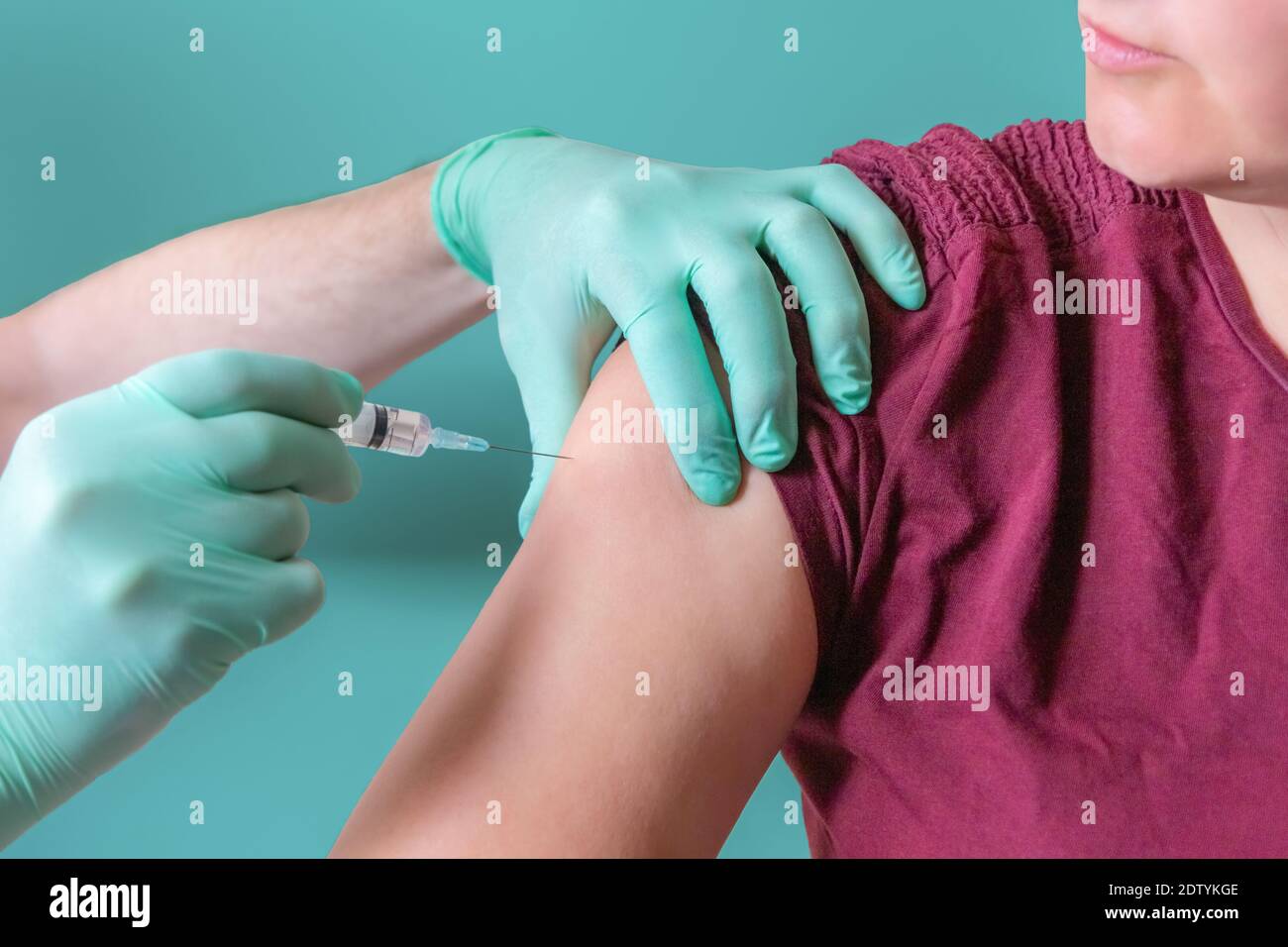 La seringue de maintien de l'infirmière permet l'injection au patient féminin. Femme vaccinée dans un centre de vaccination. Vaccination à l'épaule. Sécurité contre le coronavirus Banque D'Images
