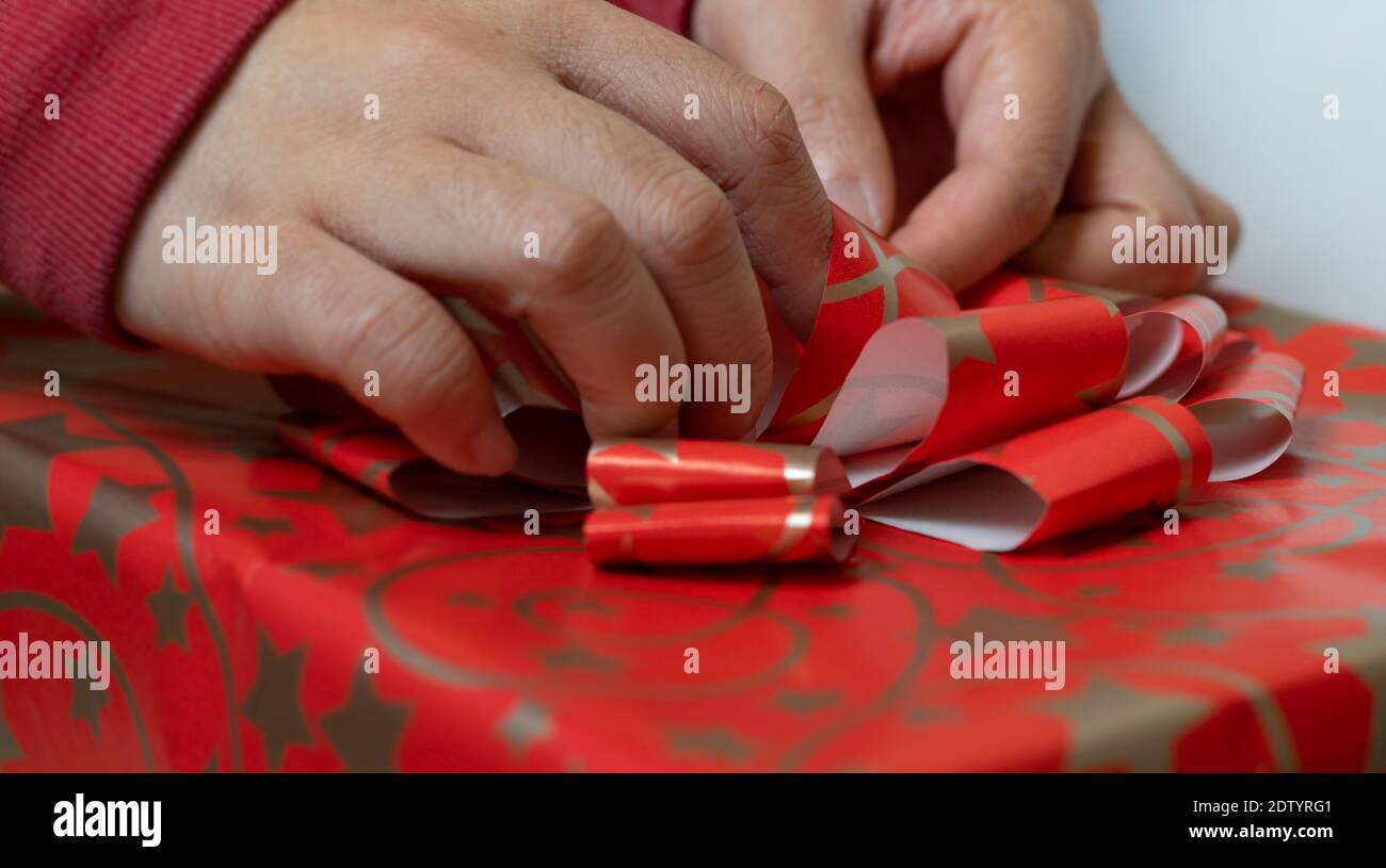 Vue rapprochée de la main de la personne âgée faisant un arc avec papier d'emballage Banque D'Images