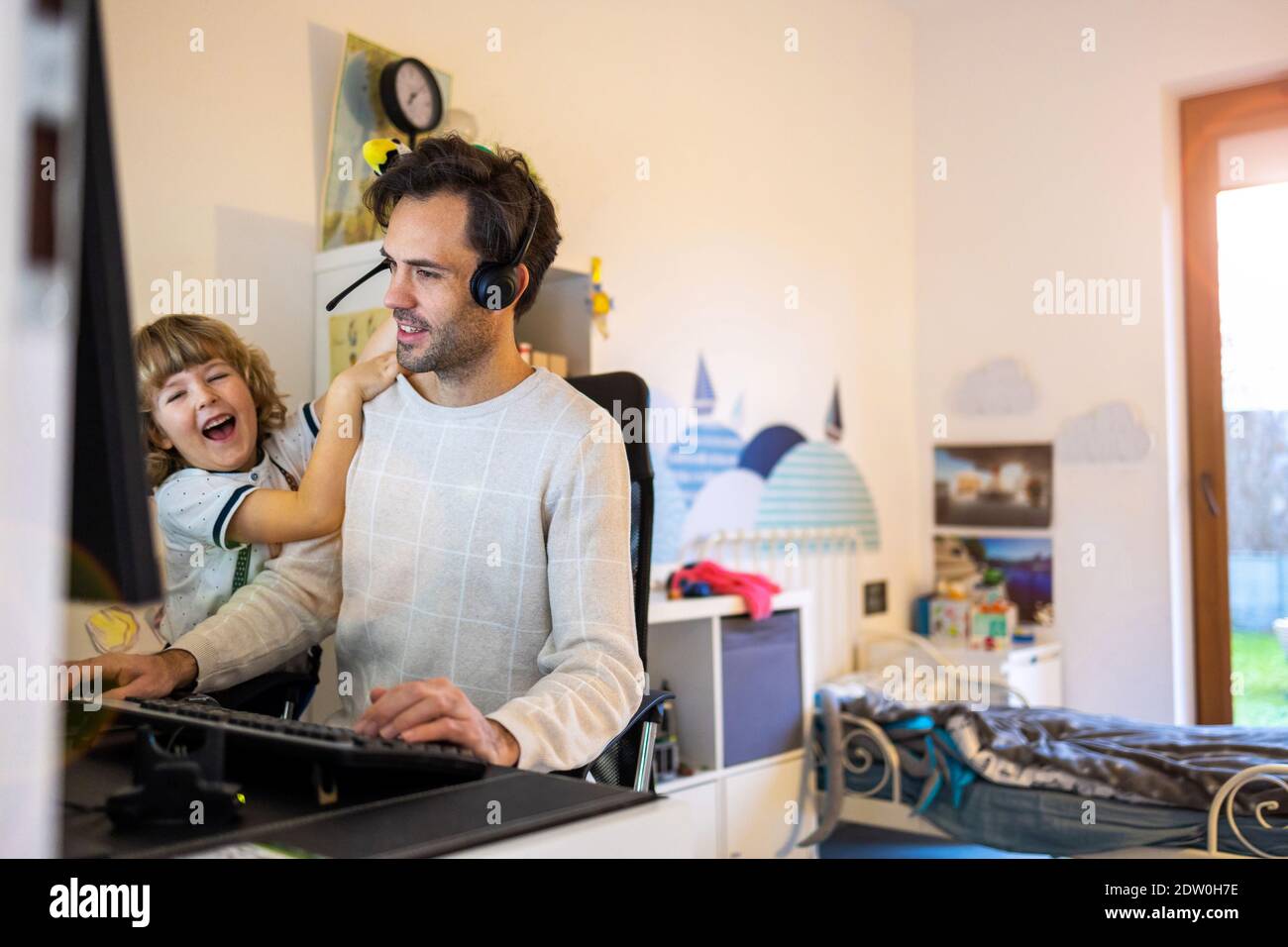 Père essayant de travailler de la maison avec ses enfants Banque D'Images