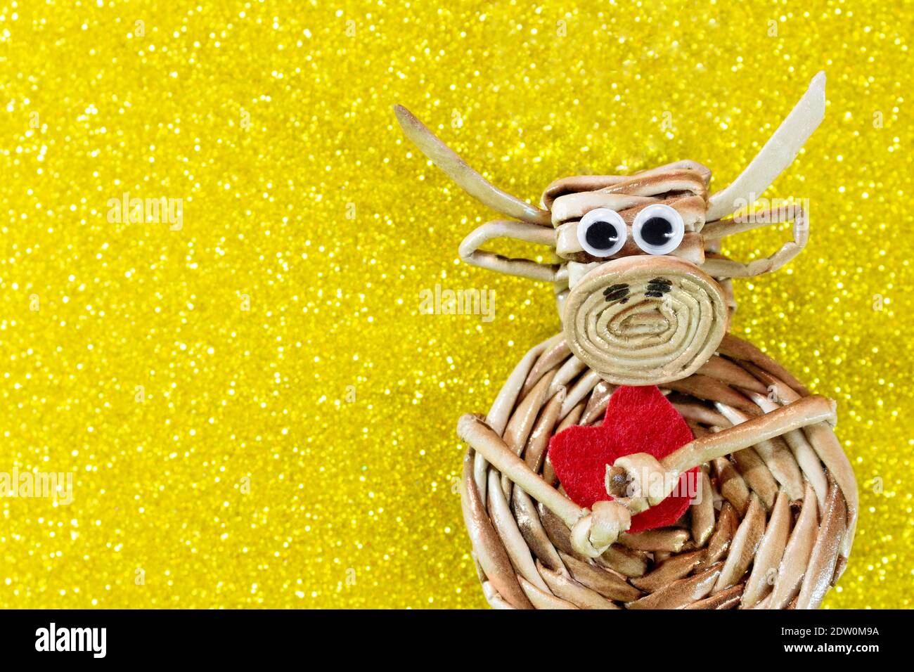 Boeuf avec coeur rouge sur fond jaune avec des sparkles. Arrière-plan de Noël et du nouvel an. Symbole de l'année. Saint Valentin. Copier l'espace Banque D'Images