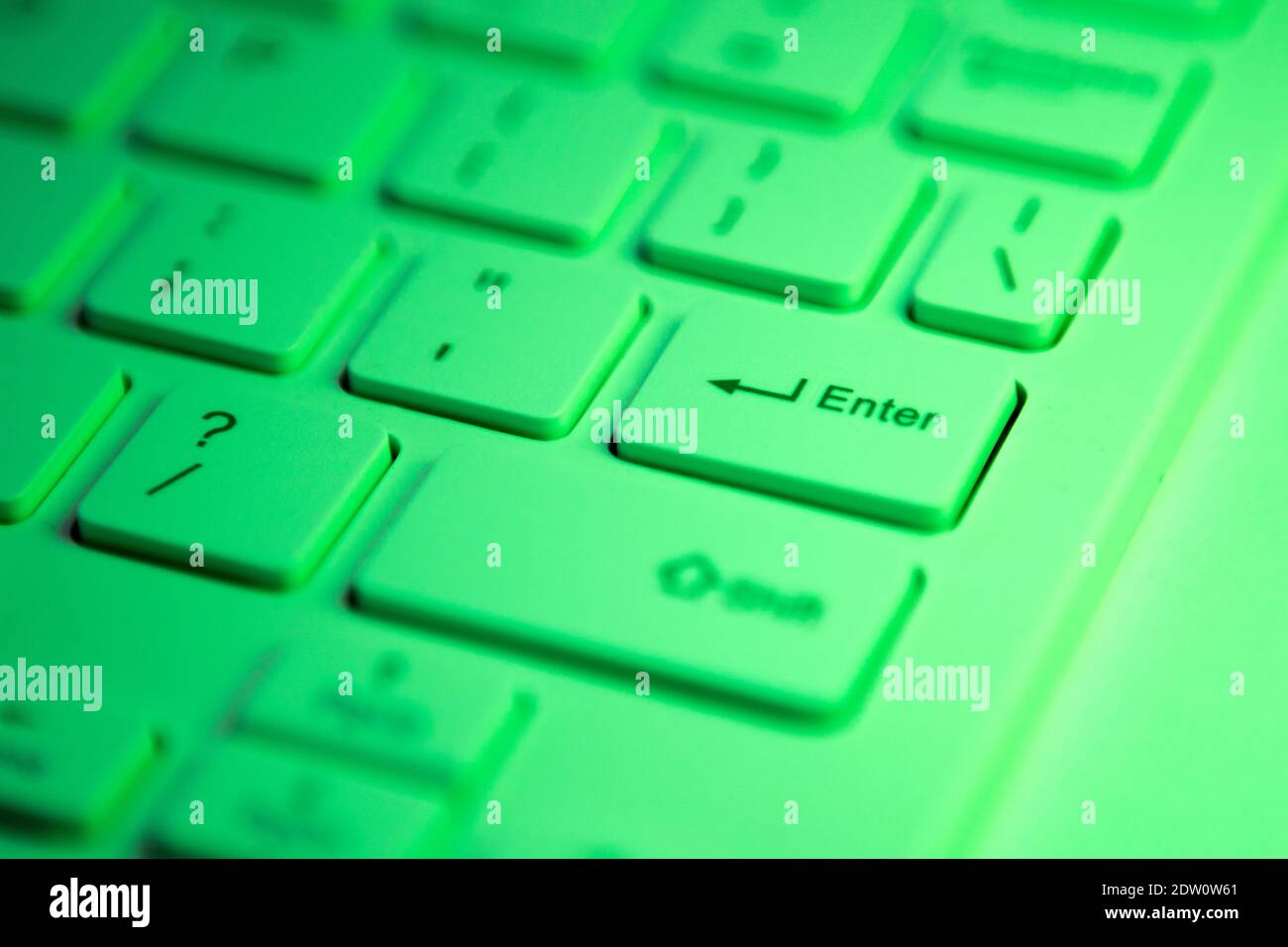 Gros plan sur une touche entrée en surbrillance verte activée un clavier d'ordinateur Banque D'Images
