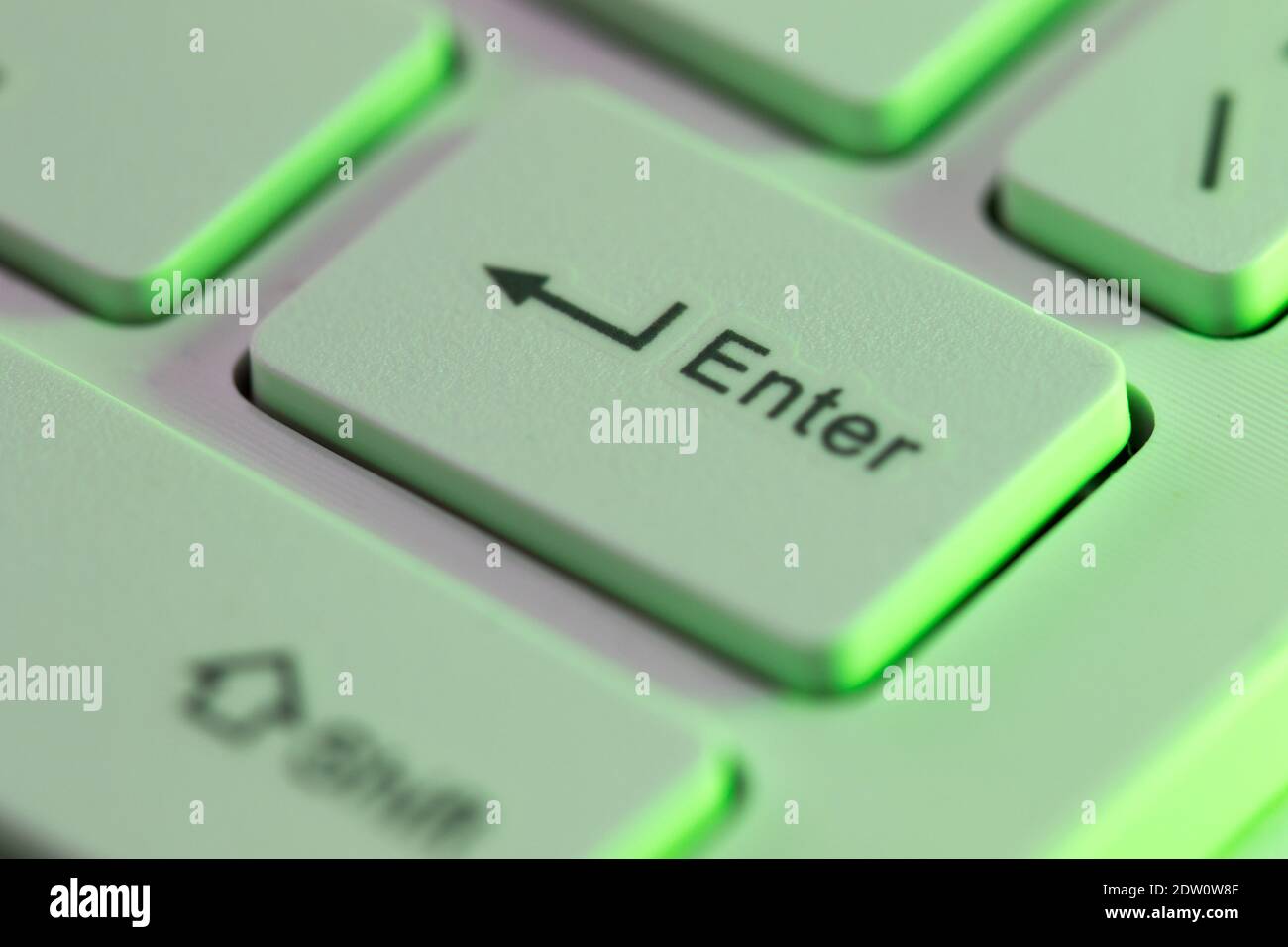 Gros plan sur une touche entrée en surbrillance verte activée un clavier d'ordinateur Banque D'Images